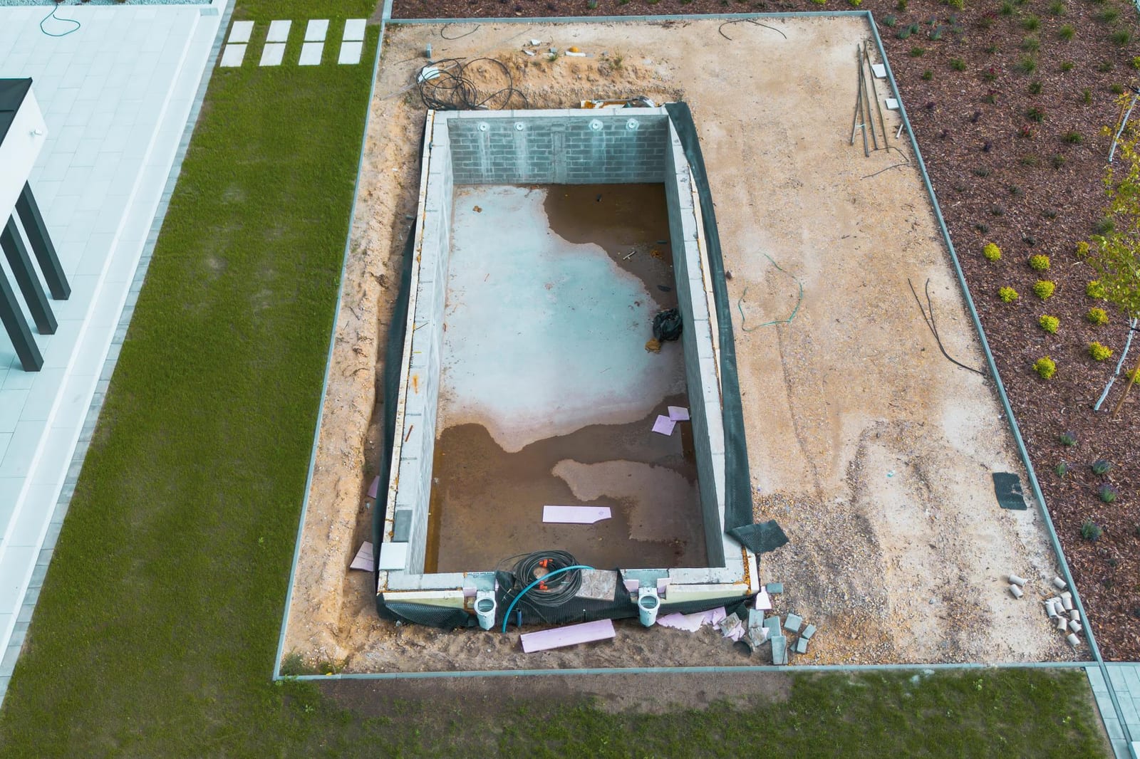 Hot tub delivery crew positioning a spa unit on a reinforced backyard pad